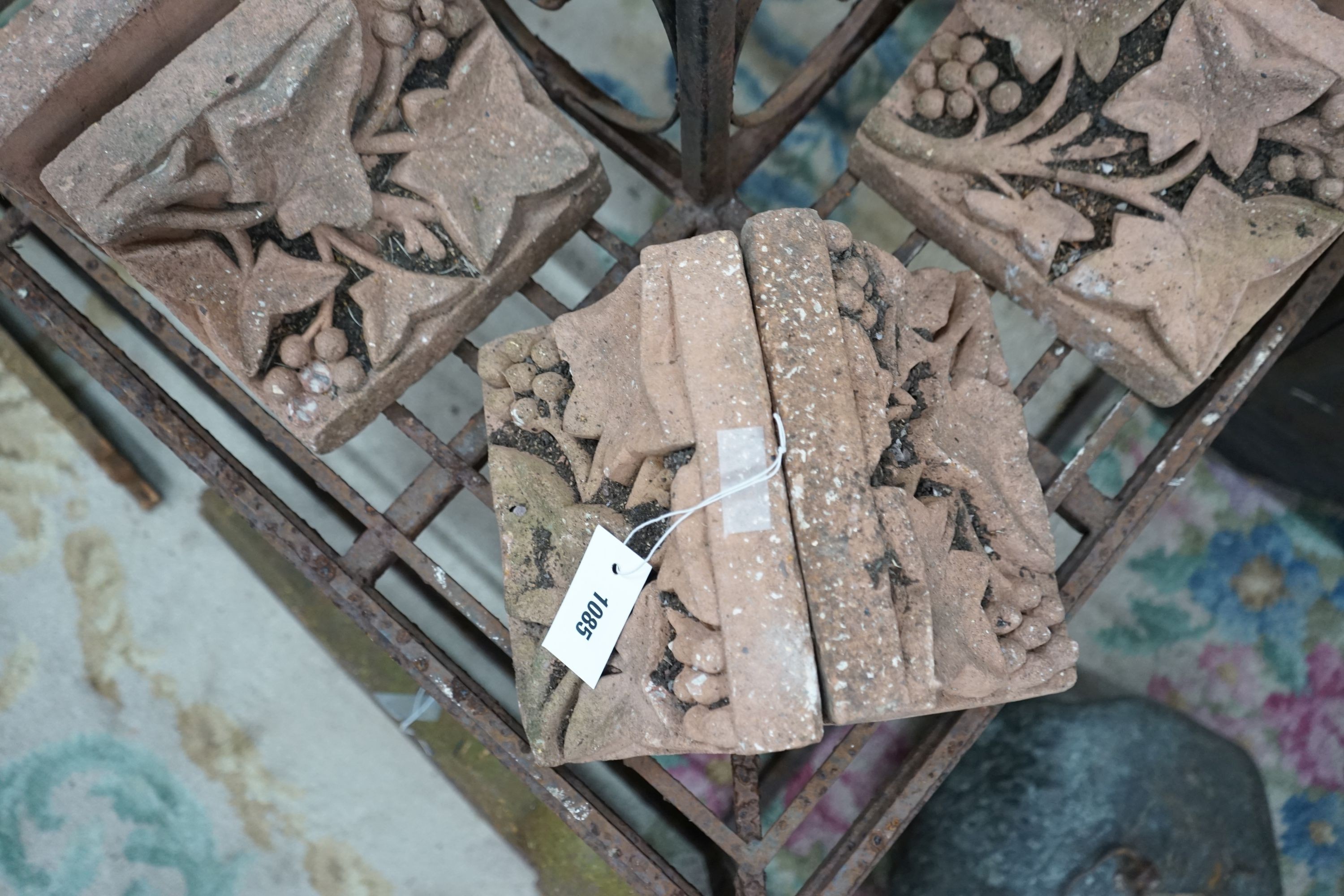 Fourteen terracotta edging tiles moulded with fruiting vines, each width 23cm, depth 14cm, height 15cm